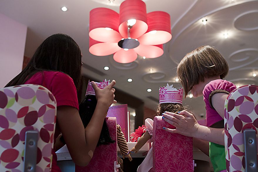 Laura Richards, 11, and Michelle Finta, 12, from Burtonsville, Md. sit with their dolls at the American Girl Bistro during the store's soft opening at Tyson's Corner Center in McLean, Va. on Thursday, June 16, 2011. The grand opening of American Girl is Saturday, June 18. (Pratik Shah/The Washington Times)