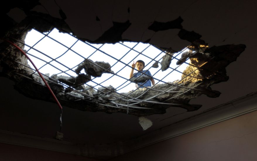 A Libyan child inspects damage caused by a rocket which fell through the roof of a house in Misrata, Libya, Friday, June 17, 2011, one of three that hit the city. East of Tripoli, Gadhafi's forces exchanged intense shelling with rebels who are slowly breaking the government siege on their western stronghold, the port city of Misrata. (AP Photo/Hassan Ammar)