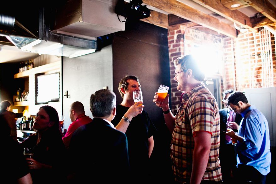 DC Brau President Jeff Hancock (center) chats with Ben Matz as they hoist DC Brau's Corruption India Pale Ale at Smith Commons Bar in Northeast recently. Mr. Matz has plans to start another D.C. brewery, called Chocolate City. (Drew Angerer/The Washington Times)