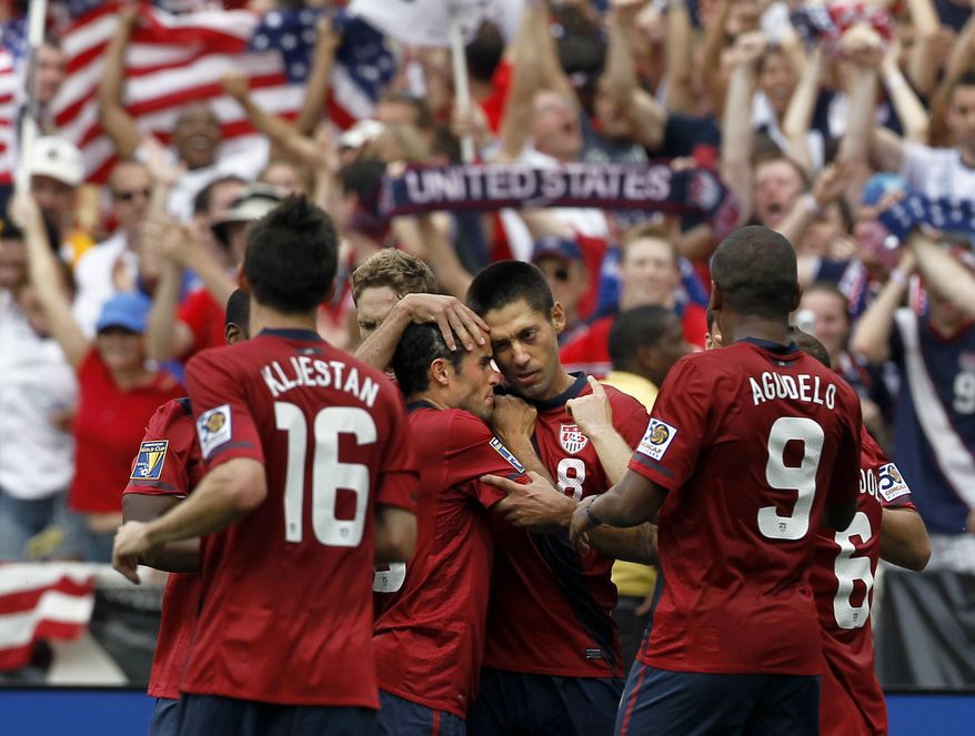 United States' Clint Dempsey (8) is surrounded by his teammates after his goal during the second half of a CONCACAF Gold Cup quarterfinal soccer match with Jamaica on Sunday, June 19, 2011 at RFK Stadium in Washington. The United States won 2-0. (AP Photo/Alex Brandon)