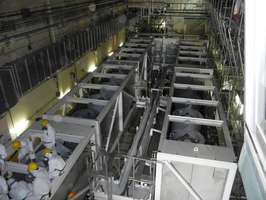 **FILE** In this photo from June 1, 2011, workers inspect equipments inside the cesium absorption tower, part of the radioactive water processing facilities at Fukushima Dai-ichi nuclear power plant in Okuma, Fukushima Prefecture, northeastern Japan. (Associated Press/Tokyo Electric Power Co.)