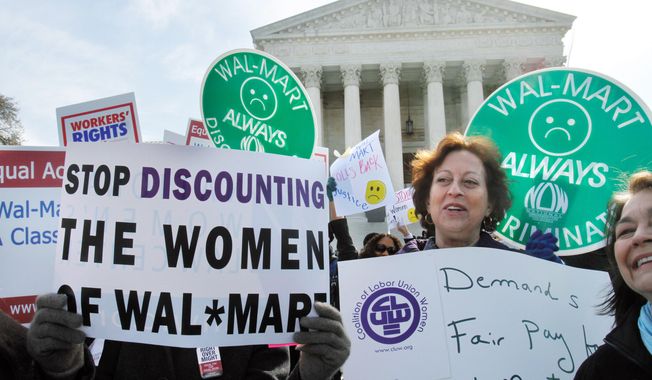 Carol Rosenblatt (right), of the District, takes part in a rally at the Supreme Court on March 29 in support of plaintiffs in a case of female employees against Wal-Mart.  The National Women&#x27;s Law Center decried Monday&#x27;s ruling, which held there were too many female plaintiffs in too many different jobs to justify a class-action lawsuit. (Associated Press)