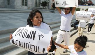 **FILE** Eva Cardenas, a community organizer who works for Georgia Latino Alliance for Human Rights, marches in front of the Federal Court with other protesters in Atlanta on June 20, 2011. (Associated Press)