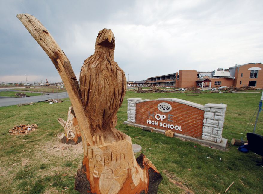 A recently carved eagle representing the school's mascot stands guard in front of what was Joplin High School. It was carved by a Tennessee artist from the remnants of an oak tree that was sliced in two and stripped of its bark by the twister. (Associated Press)