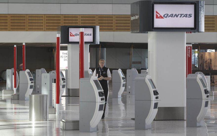 A sole Qantas worker stands at an empty check-in terminal at Sydney Airport, Australia, Tuesday, June 21, 2011. Several international and domestic flights through Australian airports were canceled Tuesday due to an ash cloud from a Chilean volcano moving into the country's airspace. (AP Photo/Rob Griffith)