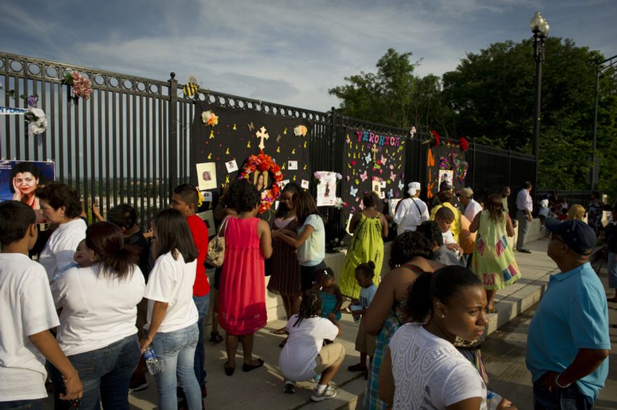 Family and friends of some of the crash victims spend time at a personal, makeshift memorial on The Charles A. Langley Bridge near the Fort Totten Metro Station in Washington, D.C. (Rod Lamkey Jr./The Washington Times)