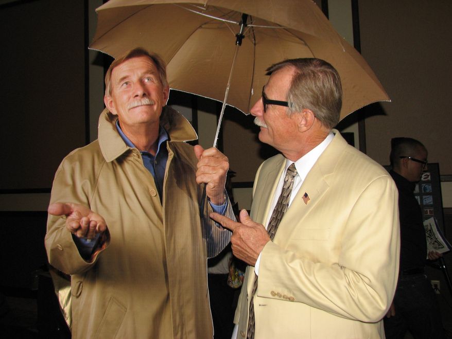Yuma Mayor Al Krieger stands by a life-size cutout of himself in Yuma, Ariz., on June 16, 2011. When placed in hotel lobbies, the cutout of the mayor wearing a raincoat and toting an umbrella will signal an official cloudy day, triggering Code Gloom, a promotion that will offer hotel guests free meals on sunless days. (AP Photo/Yuma Sun, Mara Knaub)