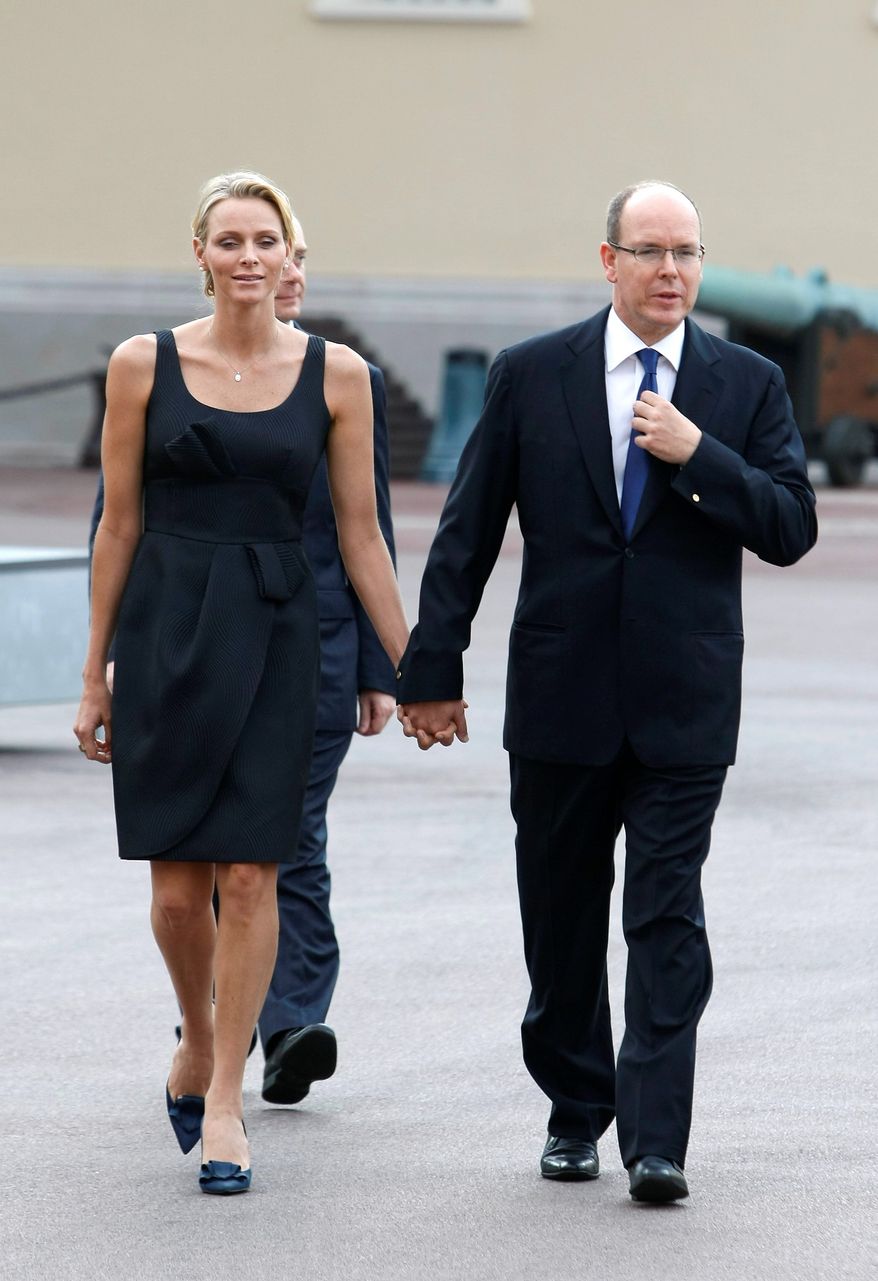 Prince Albert II of Monaco and his fiancee, Charlene Wittstock, attend the St. Jean religious parade on Thursday in Monaco. The couple will be married in a civil ceremony on Friday. (Associated Press)