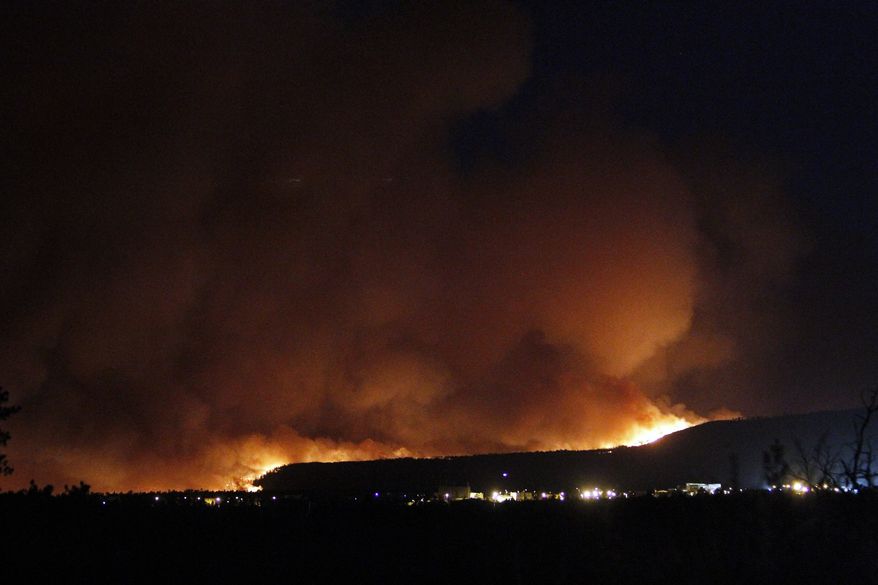 A wildfire crests over the hills above Los Alamos National Labs on June 26, 2011, in New Mexico. (Associated Press/The New Mexican)