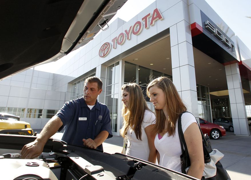 Billy Garlin (left), a sales and leasing consultant at the Big Two Toyota Scion of Chandler car dealership, shows Lacey Rivera (center) and her sister Shelbey Kearns the new car Ms. Rivera had just purchased, in Chandler, Ariz., on Thursday, June 23, 2011. (AP Photo/Ross D. Franklin)