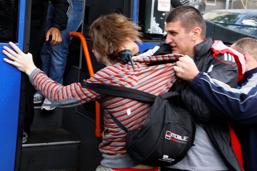 ASSOCIATED PRESS
Belarus plainclothes policemen detain a protester during a "Revolution by Social Networks" rally in Minsk on Wednesday. The Vesna rights advocacy group said more than 100 people were arrested after police lost patience and began rounding up the demonstrators, beating many with truncheons.
