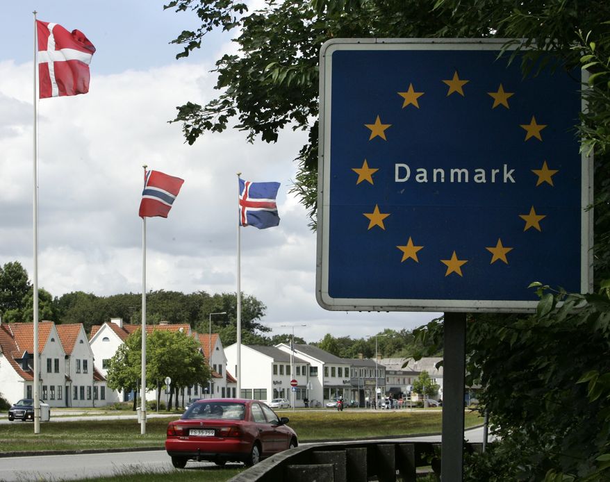 In this photo taken Friday, June 24, 2011, a car crosses the German-Danish border at Krusaa, Denmark. An inattentive driver could easily miss the flags and road signs that mark the border with Germany on the road leading into the small Danish town of Krusaa. On Friday, July 1, 2011, Danish lawmakers will vote on a plan to re-establish permanent customs checkpoints in Krusaa and other border crossings. (AP Photo/Heribert Proepper)