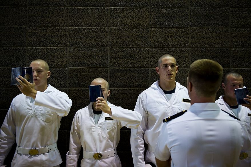 Incoming students, or plebes, read their Reef Points booklets as they await further instructions during Induction Day in Alumni Hall at the U.S. Naval Academy in Annapolis on Thursday, June 30, 2011. The Reef Points serve as an introduction to the Navy, and the plebes are expected to memorize all of the facts in the book. They are instructed to hold the books squarely in front of their face as they read them. (Drew Angerer/The Washington Times)