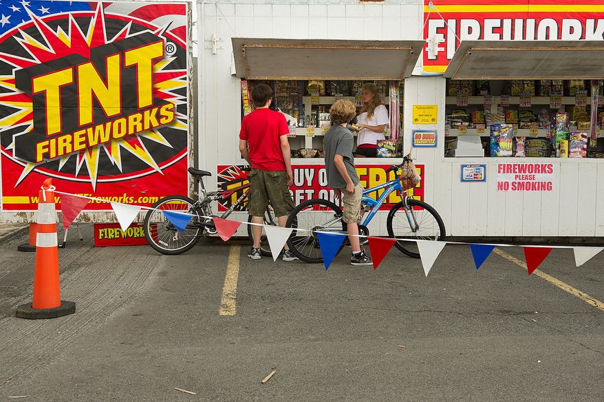 PHOTOGRAPHS BY BARBARA L. SALISBURY/THE WASHINGTON TIMES
Two boys ask questions about the fireworks for sale at the TNT fireworks booth in Manassas, Va. They were turned away because they weren't yet 16 years old, the minimum age to buy fireworks.