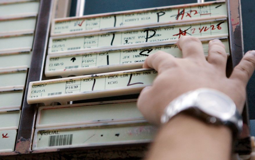The control tower at Ronald Reagan Washington National Airport includes flight progress strips. The Federal Aviation Administration is creating a revolutionary air traffic system, but various factors have delayed the program. (Associated Press)