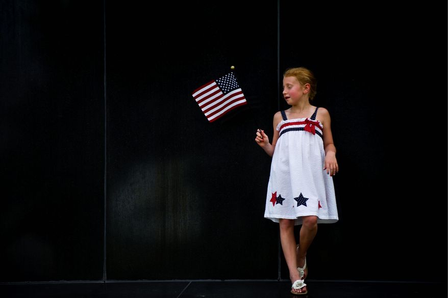 Anne Byrd Fickling, 7, of Fredericksburg, Va., waits for the sun to set and the fireworks to start at the base of the Iwo Jima Memorial in Arlington. (Drew Angerer/The Washington Times)