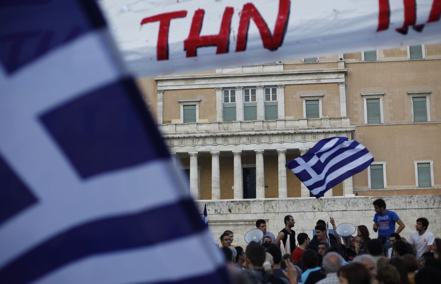 Protesters gather in front of the Greek Parliament during a peaceful rally against plans for new austerity measures in central Athens on Monday, June 13, 2011. Standard & Poor's international credit rating agency on Monday further slashed the debt-ridden country's rating, warned that Greece was more likely to default. (AP Photo / Kostas Tsironis)
