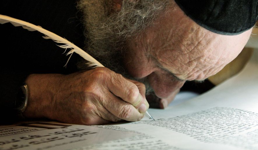 An ultra-Orthodox Jewish man writes some of the last words in a Torah scroll before it is taken from the Western Wall into the Hurva synagogue in Jerusalem&#39;s Old City. Software developed by an Israeli team of scholars is giving intriguing new hints about what researchers believe to be the multiple hands that wrote the Bible. (Associated Press)