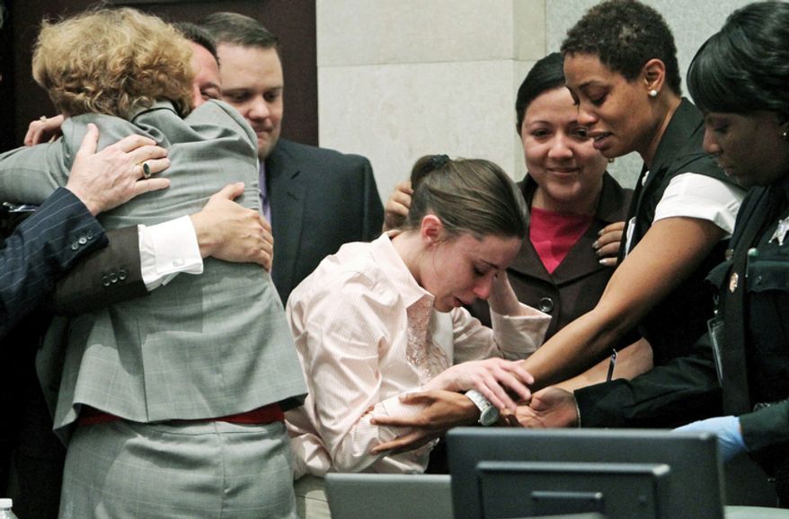 Casey Anthony, center, is overcome with as her lawyers, Jose Baez hugs Dorothy Clay Sims, left, after she was acquitted of murder charges. (AP Photo/Red Huber, Pool)