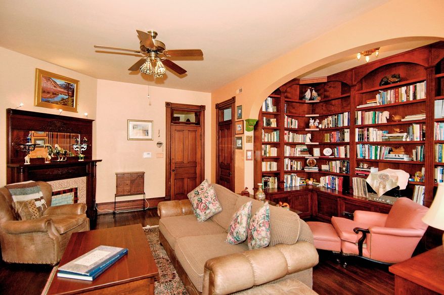 The upper-level library has a reading nook with built-in bookshelves tucked under an arched ceiling. The room also could be a bedroom.