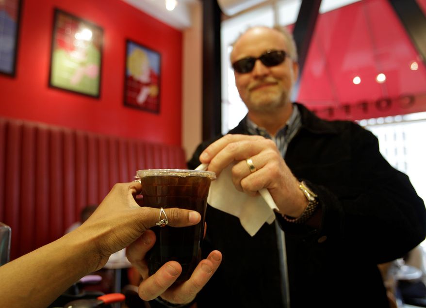 This Wednesday, April 27, 2011 photo shows customer Brad Shaffer as he is served an iced coffee at Cafe Madeleine in San Francisco. (AP Photo/Eric Risberg)