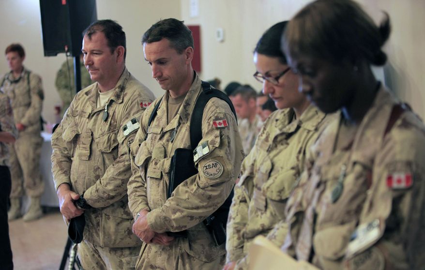 Canadian soldiers pay tribute to their fallen comrades during a transfer-of-command ceremony at Kandahar Airfield in Afghanistan on Thursday, July 7, 2011. (AP Photo/Rafiq Maqbool)
