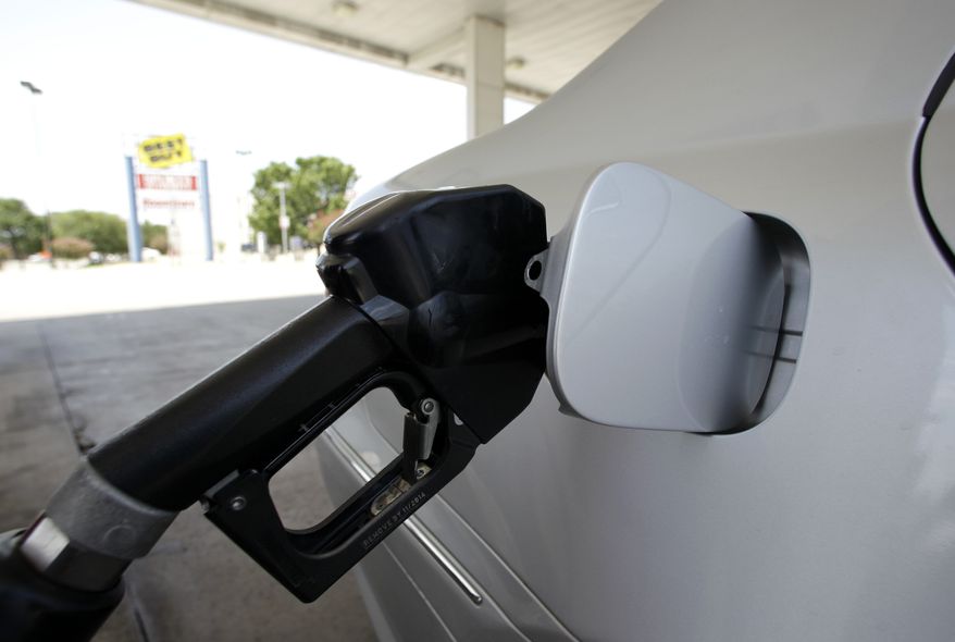 A gasoline pump fills up a vehicle. (Associated Press)**FILE**