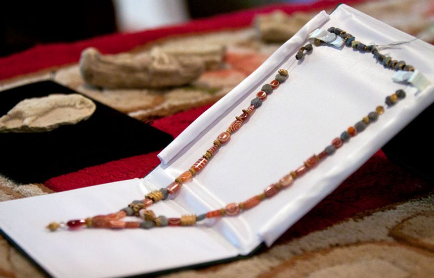 A Western Asiatic necklace (circa third to second millennium B.C.) sits on a table with other artifacts during a repatriation ceremony of Iraqi antiquities. (Pratik Shah/The Washington Times)