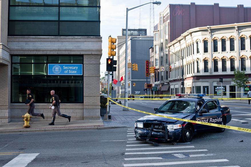 A Grand Rapids police car that was both hit and fired upon sits on the corner of Division and Fulton in Grand Rapids, Mich. after Roderick Dantzler, suspected in fatal shootings at two separate homes that killed seven people, led police on a high speed chase Thursday, July 7, 2011. (AP Photo/The Grand Rapids Press, Ryan M.L. Young)