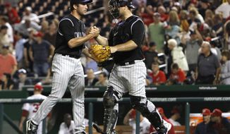 Colorado Rockies relief pitcher Huston Street congratulates catcher Chris Iannetta, after they won their baseball game against the Washington Nationals 3-2 at Nationals Park on Friday. (AP Photo/Jacquelyn Martin)