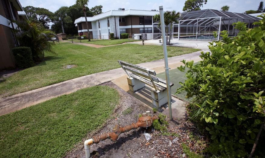 In this June 15, 2011 photo, an empty park bench and rusting pipe sit near the swimming pool at the Inlet House, in Fort Pierce, Fla. The complex was an affordable place that the 55-and-older set aspired to. But now the Homeowner's association has levied a $6,000 assessment on every homeowner and then foreclosed on seniors who did not owe the bank a dime but could not afford the association bill. (AP Photo/J Pat Carter)