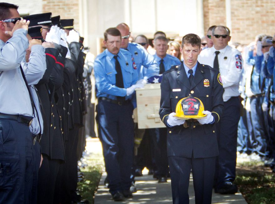 Conroe Fire Department's Greg Nesom carries the helmet of Shannon Stone as he leads the casket from the church at the funeral for firefighter Lt. Stone, in Brownwood, Texas, on Monday, July 11, 2011. Stone fell to his death while trying to catch a souvenir baseball at a Texas Rangers game. (AP Photo/Star-Telegram, Joyce Marshall)