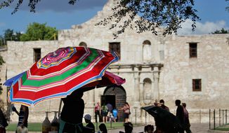 A vendor near the Alamo opens a umbrella to provide protection from the sun, Monday, July 11, 2011, in San Antonio, Texas. (AP Photo/Eric Gay)