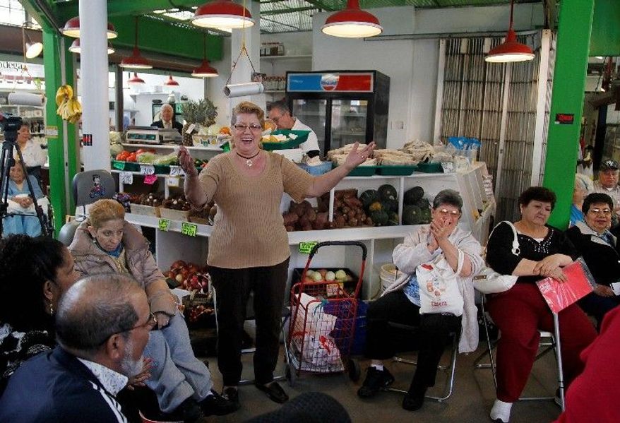 ASSOCIATED PRESS
Jenny Rodriquez, 69, leads a gathering of seniors in song during a visit to La Marqueta in New York's East Harlem neighborhood. School buses use the time between their morning and afternoon runs to transport seniors like Ms. Rodriquez to activities as part of the city's "Age-Friendly NYC" program.