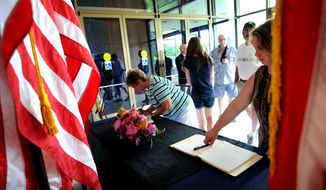 People sign the condolence book for former first lady Betty Ford in the front lobby of the Gerald R. Ford Presidential Museum in Grand Rapids, Mich., on Sunday, July 10, 2011. Mrs. Ford died Friday at age 93. (AP Photo/The Grand Rapids Press, Katy Batdorff)