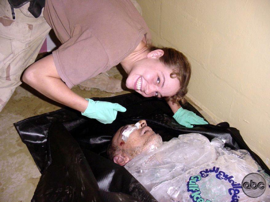 ** FILE ** Army Spc. Sabrina Harman of the 372nd Military Police Company poses with the body of Iraqi detainee Manadel al-Jamadi, who is packed in ice, at the Abu Ghraib prison in Baghdad in 2003. (Associated Press/ABC News)