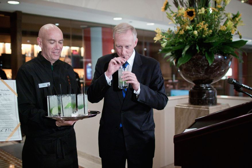 D.C. Council member Jack Evans (right) takes a sip of a "Rickey" cocktail, which he said was enjoyed by congressmen in the 19th century. He sampled it at the JW Marriott in the District on Thursday. (Pratik Shah/The Washington Times)