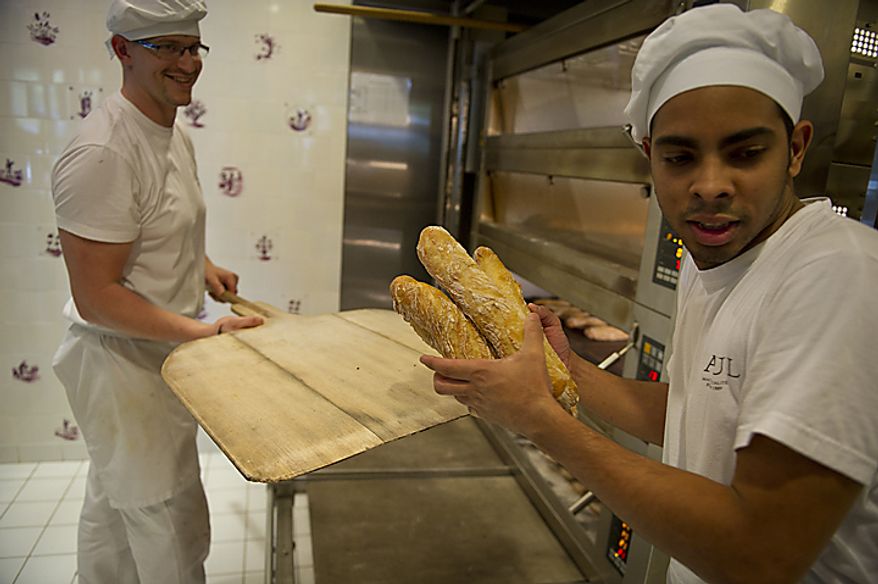 Bakers Frederic Lafrenoy (left) and Francisco Angulo unload loaves of freshly baked baguettes at Paul Bakery in Washington, D.C., Thursday, July 14, 2011. Some of these loaves will be used in the Baguette Relay Races, held at the United States Navy Memorial, to honor Bastille Day. (Rod Lamkey Jr/The Washington Times)