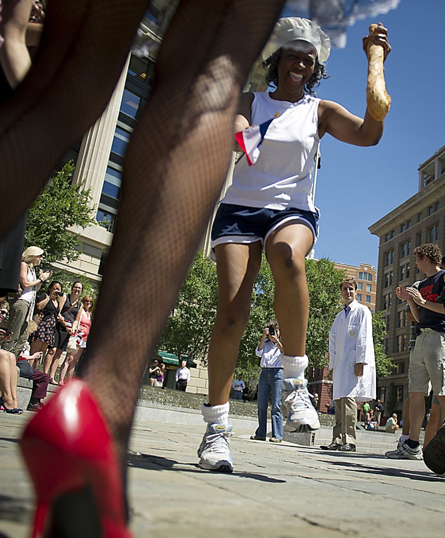 Mary Brown of Fairfax Station, Va., sports a chef's cap and holds a baguette, as she makes her way around the United States Navy Memorial and crosses the finish line in the Baguette Relay Races, to honor Bastille Day in Washington, D.C., Thursday, July 14, 2011. The races were sponsored by Paul Bakery. (Rod Lamkey Jr/The Washington Times)