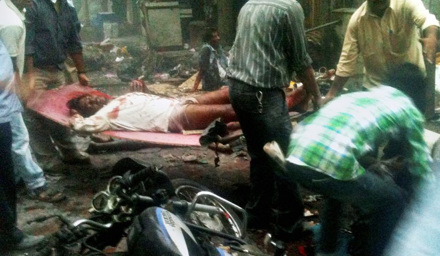 DEVASTATING: A victim of a bomb explosion is carried away moments after detonation at Zaveri Bazaar in Mumbai. Near-simultaneous blasts rocked three upscale neighborhoods during evening rush hour in India&#39;s commerce capital Wednesday, killing at least 21 people and injuring 141 others. (Associated Press)