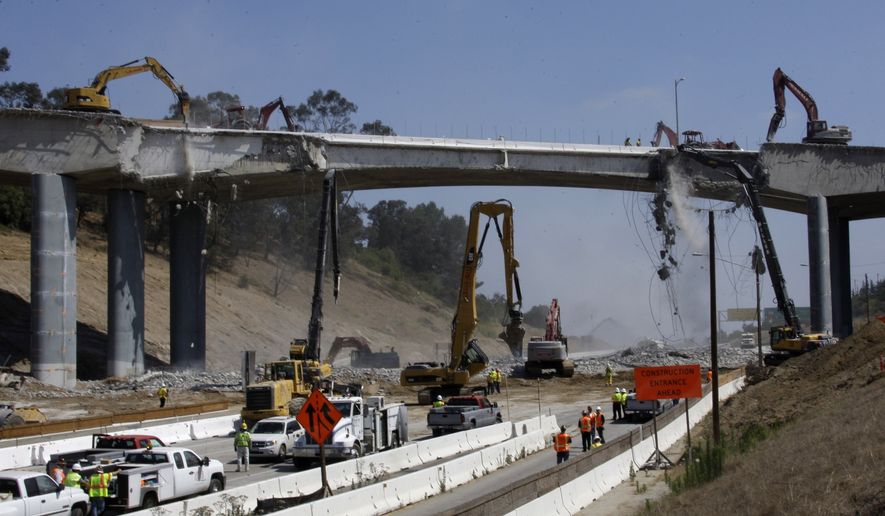 Pneumatic hammers from above and below continue the demolition of two lanes of Mulholland Drive bridge over Interstate 405 in Los Angeles Saturday, July 16, 2011. Ramps to the normally clogged Interstate 405 were shut down Friday evening before the entire roadway was closed at midnight, setting the stage for a 53-hour bridge demolition project that will test whether this car-dependent city can change its driving habits for a weekend. (AP Photo/Reed Saxon)