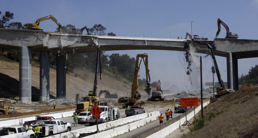 Pneumatic hammers from above and below continue the demolition of two lanes of Mulholland Drive bridge over Interstate 405 in Los Angeles Saturday, July 16, 2011. Ramps to the normally clogged Interstate 405 were shut down Friday evening before the entire roadway was closed at midnight, setting the stage for a 53-hour bridge demolition project that will test whether this car-dependent city can change its driving habits for a weekend. (AP Photo/Reed Saxon)