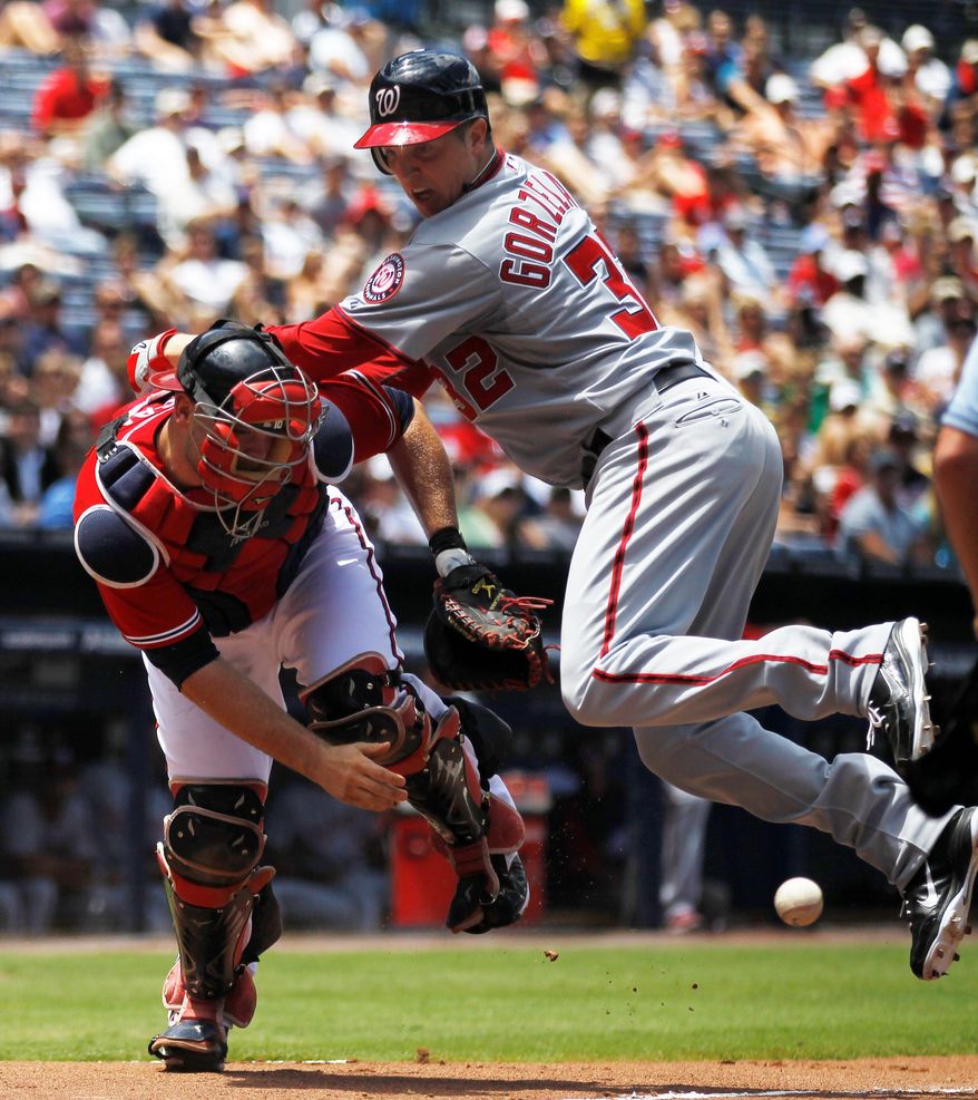 The Nationals' Tom Gorzelanny scores on Roger Bernadina's triple in the second inning, but the left-hander sprained his right ankle on the play and is listed as day to day. (Associated Press)