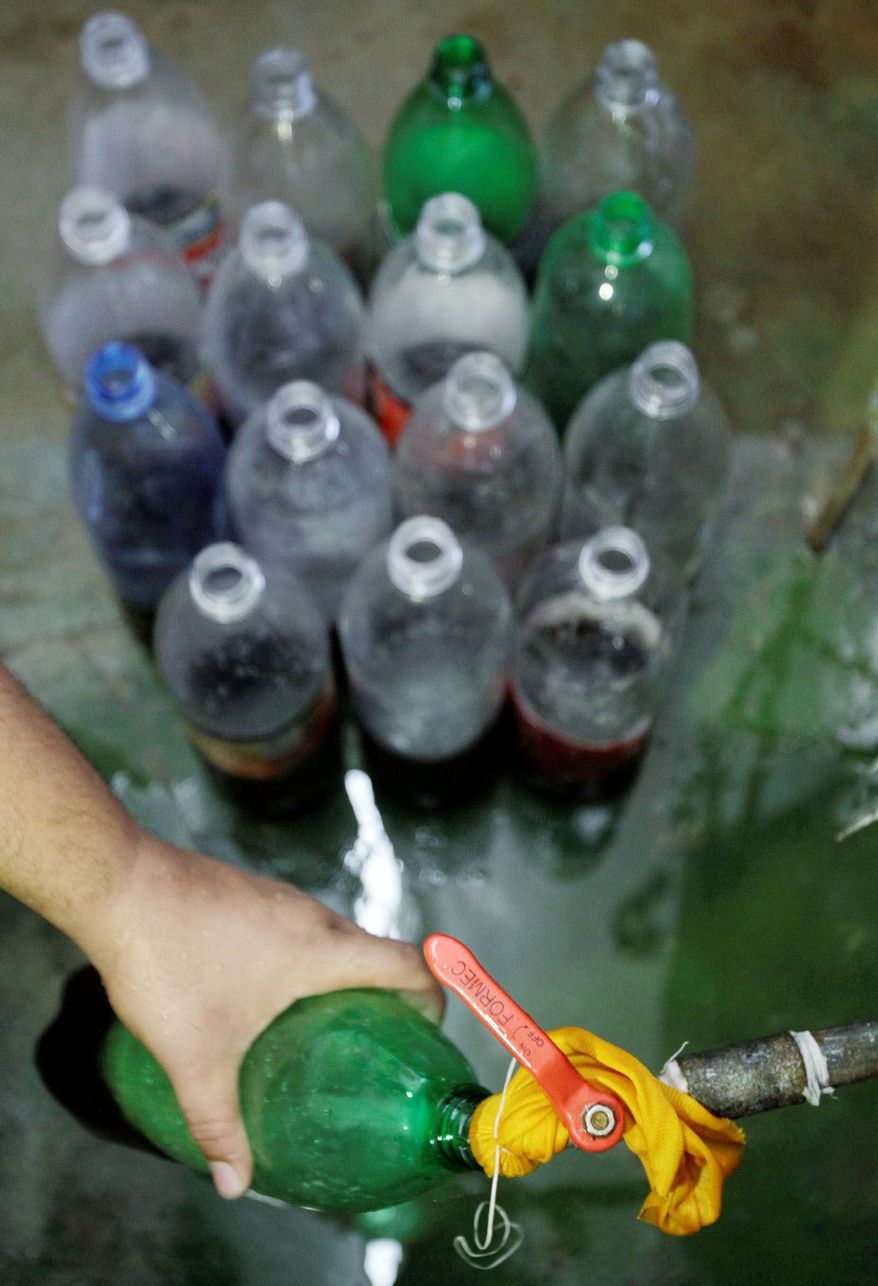 Roberto, a Cuban entrepreneur on the sly, fills bottles with a homemade soft drink to sell from his home in Havana. (Associated Press)