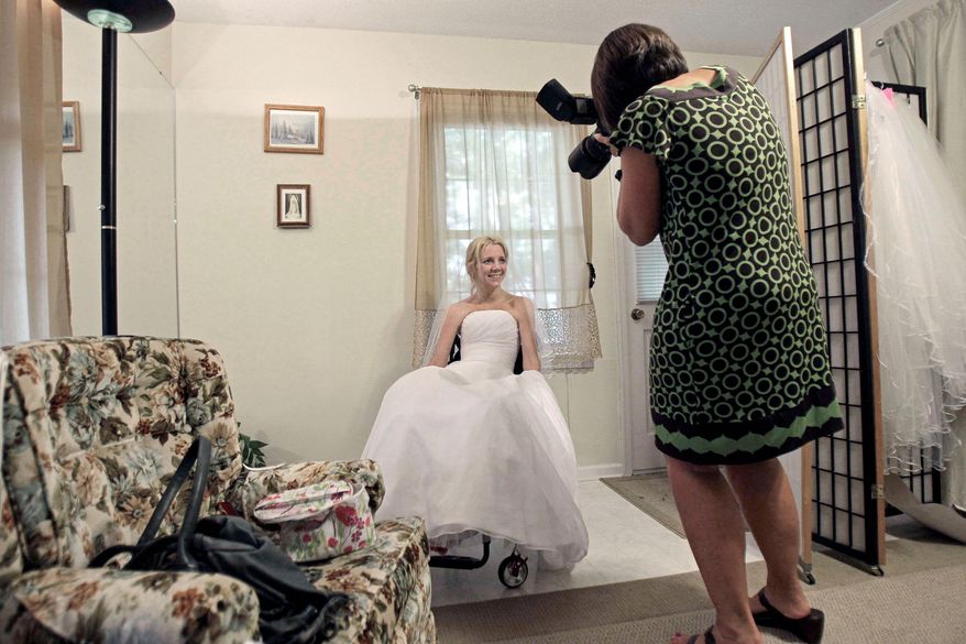 ASSOCIATED PRESS
Rachelle Friedman has her photo made by wedding photographer Martha Manning during the fitting for her wedding dress in Raleigh, N.C. Miss Friedman was left paralyzed after a pool accident that postponed her wedding plans.