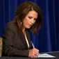 Presidential candidate Rep. Michele Bachmann, Minnesota Republican, signs the &quot;cut, cap and balance&quot; pledge during a news conference while campaigning in Columbia, S.C., on Monday. (Associated Press)