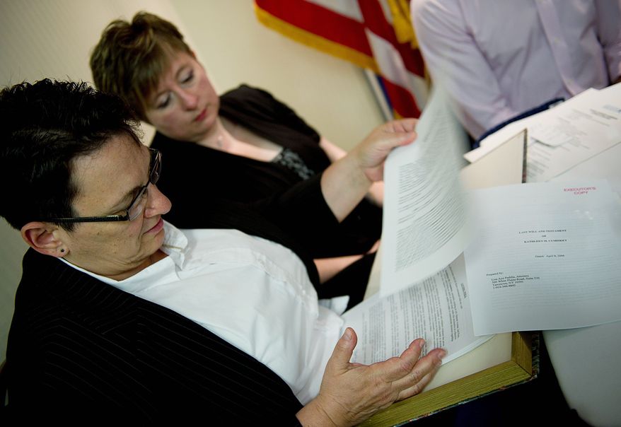 Robin Garber (left), of Staten Island, N.Y., goes through the box of legal documents that she and her wife of five years, Kathleen Cumiskey (right) say they must carry with them everywhere. The box includes their will, medical documents, marriage certificate, civil union certificate and more. (Associated Press)