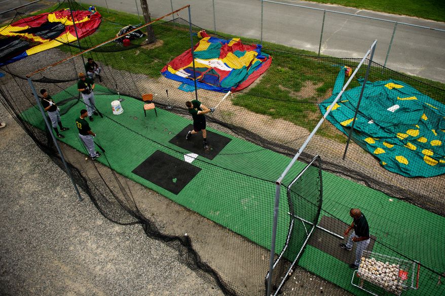 Lynchburg Hellcats players warm up in the batting cages at Pfitzner Stadium next to a road. The troubled stadium opened in 1983.