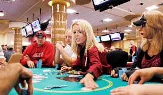Nikki Hemstad (center), a card dealer at Canterbury Park&#39;s casino in Shakopee, Minn., is back at work Thursday after the state government shutdown ended. Despite the resolution, Minnesota made no significant progress on its budget woes, leaving it on track to face the same deficit problems in two years. (Associated Press)
