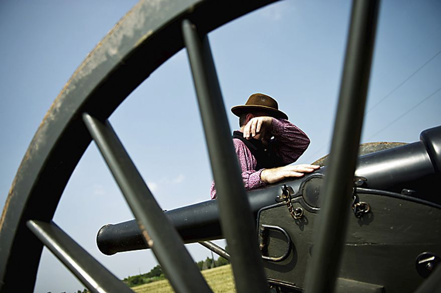 Mike DeAngelo, of Allentown, Penn., wipes sweat from his brow as he stands next to a 10 pound Parrot Rifle cannon, in Manassas, Va., Thursday, July 21, 2011. DeAngelo and his friends were camping at Camp Manassas near Jennie Dean Elementary School and were dressed as a Confederate Artillery Unit. The Parrot Rifle was capable of hitting targets a mile and a half away, according to DeAngelo. This particular cannon they were using was used in the Civil War movie "Gods and Generals." "The heat isn't too bad because we are used to it, but I definitely appreciate it when I get to be in the shade," said DeAngelo. (Drew Angerer/The Washington Times)